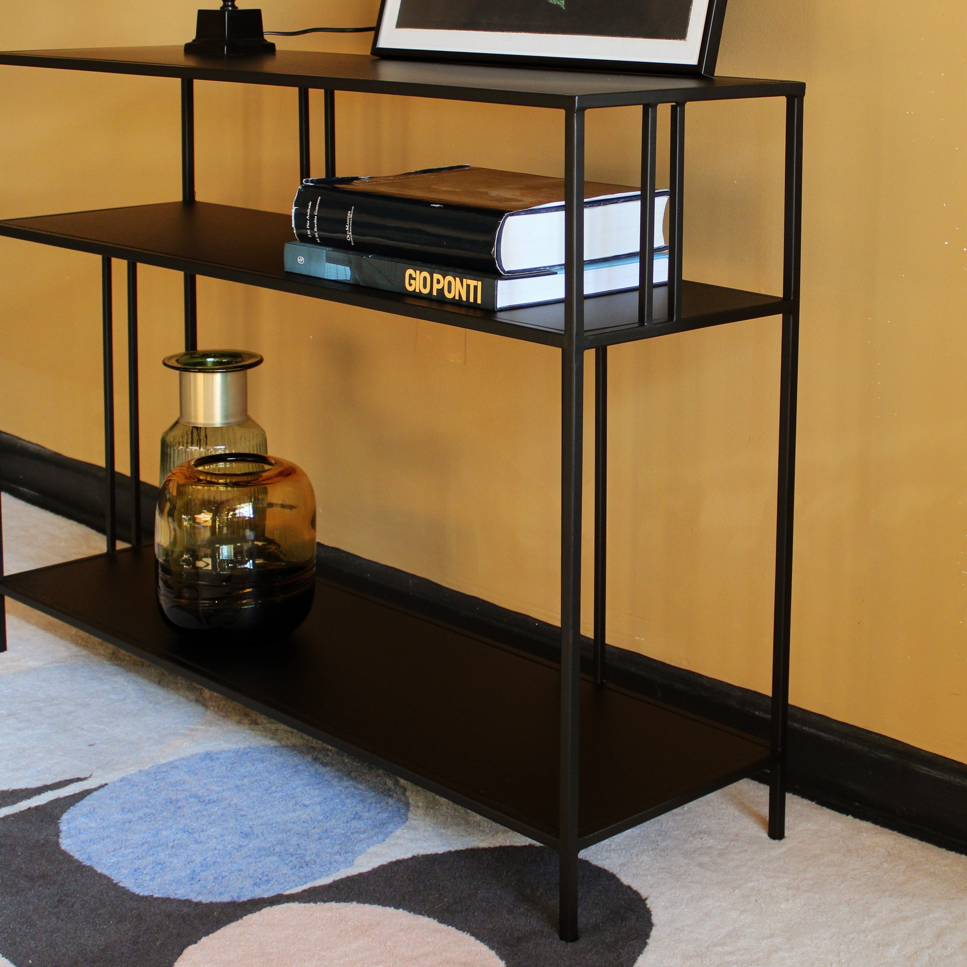 Black metal console table deals with glass top